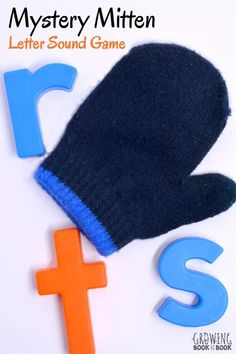 a pair of mittens sitting next to a letter sound game