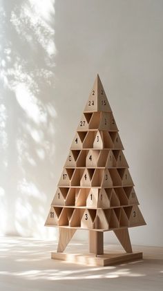 a wooden christmas tree that has numbers on it and is in the shape of a pyramid