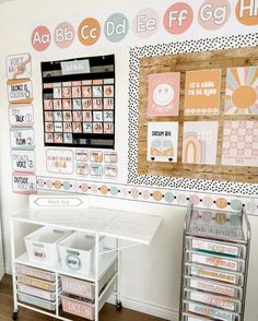 a white desk topped with lots of drawers next to a wall covered in stickers