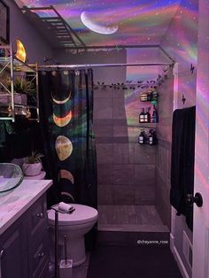 a bathroom with a toilet, sink and shower curtain in it's center area