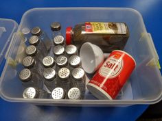 a plastic container filled with lots of food and condiments on top of a blue table