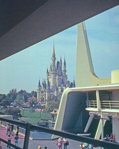 people are walking around in front of a castle at walt world's magic kingdom