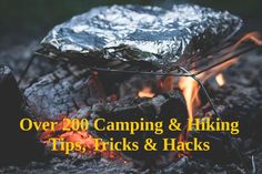 a campfire with the words over 200 camping & hiking tips, tricks and hacks