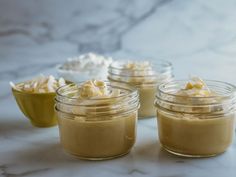 four jars filled with food sitting on top of a marble counter next to each other