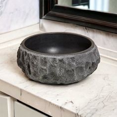 a black bowl sitting on top of a white counter