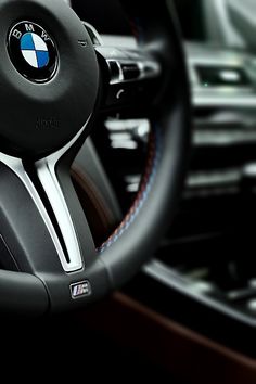 the interior of a car with an automatic steering wheel and dashboard controls, including a bmw logo