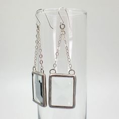 "Clear, rectangular stained glass bevel earring pair edged in silver, attached to sterling silver cable chain. The simple french hook ear wires are sterling silver.  Total Size: 3\" x 1\" each Each item by Faerie Glass is 100% uniquely hand-crafted with quality materials that are lead-free. NOTE - All photographs are taken in effort to best represent the product. Color of actual jewelry may vary slightly from photographs." Everyday Silver Glass Jewelry, Modern Rectangular Glass Jewelry, Stained Glass Earrings, Black Jewelry, Beveled Glass, Glass Earrings, Metal Design, Cable Chain, Jewelry Earrings Dangle