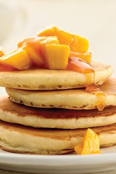 a stack of pancakes with orange syrup on top