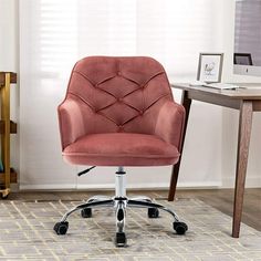 a pink office chair sitting in front of a desk with a computer on top of it