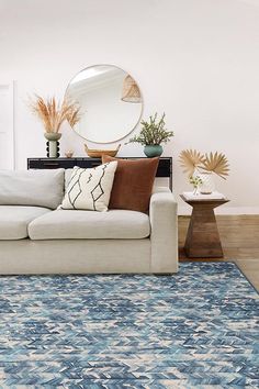 a living room filled with furniture and a large mirror on the wall above it's headboard