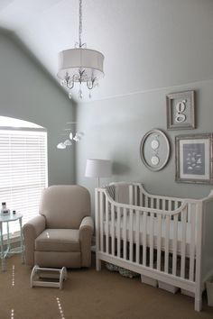 a baby's room with a crib, rocking chair and table in it