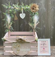 a pink wooden box with some decorations on it and a plaque in front of it