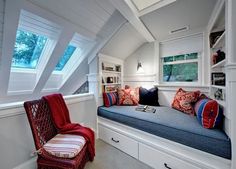 a room with a window seat and some pillows on the windows sill in it