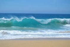 the ocean waves are crashing on the beach