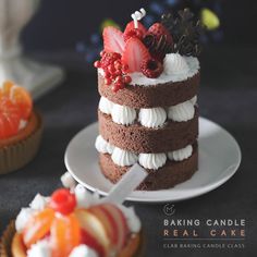 there is a chocolate cake with white frosting and fruit on top