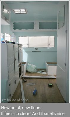 an empty room with blue paint on the walls and wood flooring in front of it