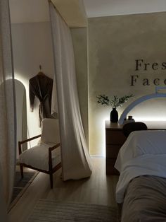 a bed room with a neatly made bed next to a window and a sign on the wall