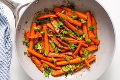 carrots are cooked in a pan with parsley and seasoning on the side