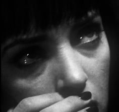 black and white photograph of a woman with her hand on her face looking at the camera