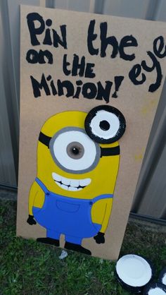 a cardboard sign that says pin the eye on the minion