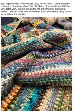 a crocheted blanket is laying on top of yarn