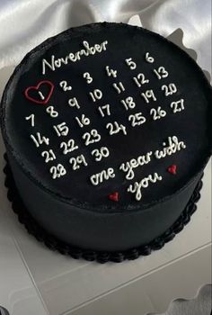 a black cake with red hearts and numbers on it