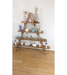 a wooden shelf with vases and other items on it in the corner of a room