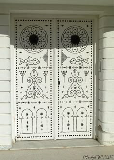 two white doors with decorative designs on them