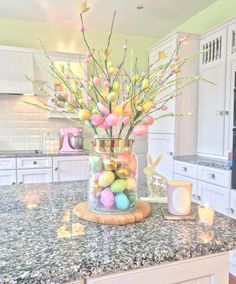 a vase filled with easter eggs on top of a kitchen counter