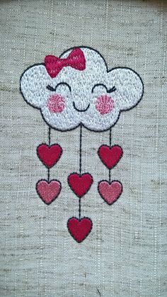 a cloud with hearts hanging from it's side on a piece of linen that has been stitched together