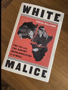 a book about white males on a wooden table