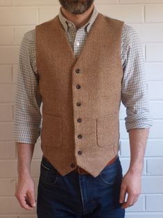 a man with a beard wearing a brown vest