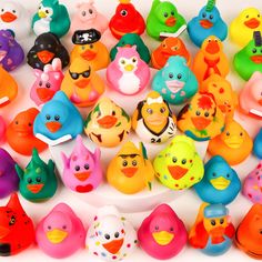 many different colored rubber ducks on a white surface