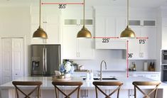 a kitchen with three pendant lights hanging from the ceiling and four bar stools at the counter