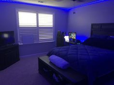 a bed room with a neatly made bed and a flat screen tv