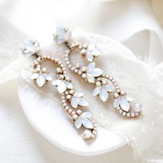 Complete your bridal look with our beautiful floral bridal earrings.  Created in a romantic style that is perfect for a boho bride or for a pop of glam to a classic bride.   - Handcrafted with genuine Austrian crystal - Each stone is set by hand in my studio - White opal crystals - Antique gold finish pictured - Available in rose gold, antique gold and rhodium (silver) finishes - Earrings measure 3 inches x 7/8 inch - Handcrafted in the US. - Nickel free and hypoallergenic - PLEASE ALLOW APPROX Glamorous White Bridal Earrings With Elegant Design, Elegant Bridal Earrings With Flower Decoration, Elegant Bridal Earrings With Flower Decoration For Wedding, Elegant White Earrings For Wedding Reception, White Crystal Earrings For Wedding, Glamorous White Bridal Earrings For Wedding, Elegant Flower Crystal Earrings For Wedding, Delicate Bridal Earrings With Flower Decoration, Glamorous White Crystal Wedding Earrings