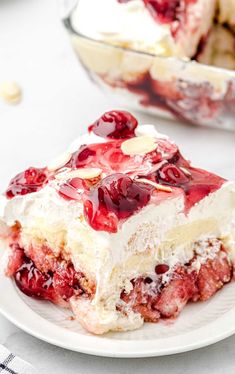 a piece of cake with cherries on it sitting on a plate next to a bowl