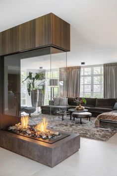 a living room with a fire place in the center and couches on either side