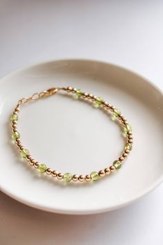 This charming August peridot bracelet will bring a cheerful pop of vibrant green to any outfit. Made with the August birthstone and a delicate gold filled beads, it's the perfect way to make a subtle statement. Peridot is said to promote good health and restful sleep. Made to last with 14k gold filled hardware. Comes in baby though adult sizes. Check out our size guide for help with sizing. We look forward to seeing you and your sweet little ones wearing your bracelets #joyfulbead. * Due to the Adjustable Green Birthstone Jewelry, Green Adjustable Birthstone Jewelry, Dainty Green Beaded Bracelets For Everyday, Dainty Green Bracelets For Everyday, Green Round Bead Bracelets For Everyday, Dainty Green Everyday Bracelets, Green Jubilee Bracelet Perfect As A Gift, Green Jubilee Bracelet As A Gift, Hypoallergenic May Birthstone Bracelets