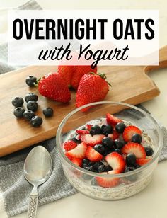 overnight oats with yogurt and berries in a glass bowl on a cutting board