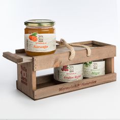 two jars of marmalade sitting on top of a wooden crate