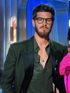 a man and woman standing next to each other in front of a tv screen with blue curtains