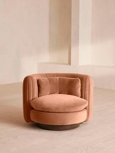 a round chair with an ottoman on the floor in front of a white wall and wooden floors