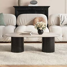 a living room with white couches and black coffee table