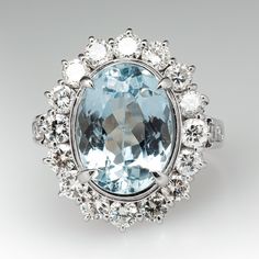 This gorgeous ring is centered with one (1) oval mixed cut natural topaz set into a four- prong setting and bordered with sixteen (16), prong/channel set, round brilliant cut diamonds. The shoulders of the ring are each accented with three (3), channel set, round brilliant cut diamonds. The ring measures 21.1mm at the top, rises 8.1mm above the finger, tapering to 2.9mm wide and 0.9mm thick at the base of the shank. This ring is currently a size 7.25. The back of the stone shows abrasion. Luxury Oval Diamond Topaz Ring, Exquisite Brilliant Cut Topaz Ring, Oval Blue Topaz Diamond Ring With Brilliant Cut, Timeless Oval Topaz Ring With Diamond, Elegant Oval Topaz Ring With Diamond Accents, Oval Topaz Ring With Rose Cut Diamonds, Timeless Oval Brilliant Cut Topaz Ring, Oval Topaz Ring With Diamond Accents, Oval Topaz Ring With Diamond Center Stone