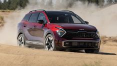 a red suv driving down a dirt road