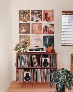 a record player is sitting on top of a shelf in front of a wall full of records