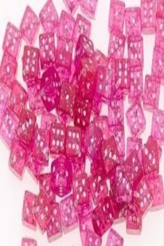 pink dices with white dots are scattered on a white surface, as if they were made from plastic