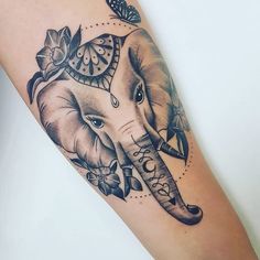 an elephant tattoo on the arm with flowers