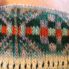 a close up of a knitted blanket with red, green and white designs on it